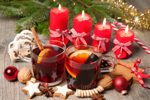 Red mulled wine on table with burning candles