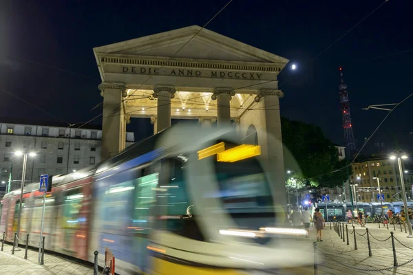 Moon and trolley car at Porta Ticinese Arch, Milan, Italy