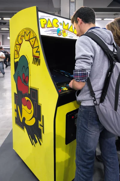 MILAN, ITALY - OCTOBER 25: Boy playing with vintage Pac Man at Games Week 2015, event dedicated to video games and electronic entertainment on OCTOBER 25, 2015 in Milan.