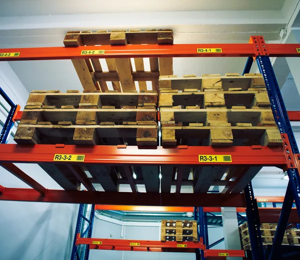 Shelves and racks with pallets in distribution warehouse interio