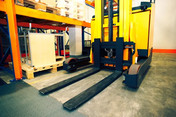 Shelves, racks and forklift  with pallets in distribution wareho