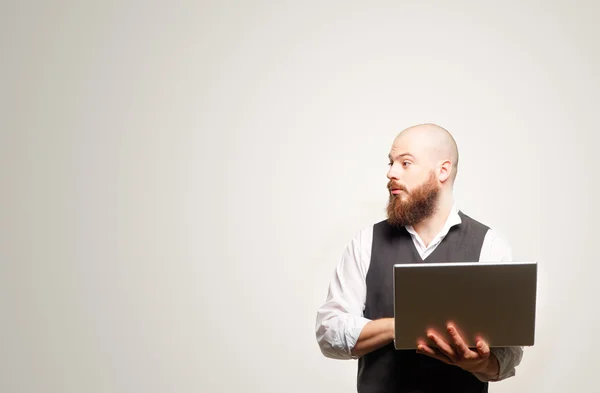 Bearded man holding his laptop