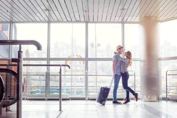 Couple hugging in airport terminal.