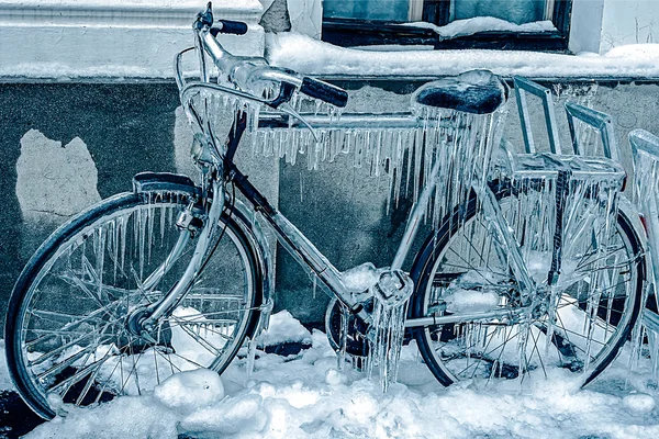 Blue look at ice icicles on a parked bicycle