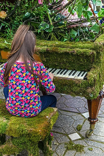 Little girl singing at one piano decorated with flowers