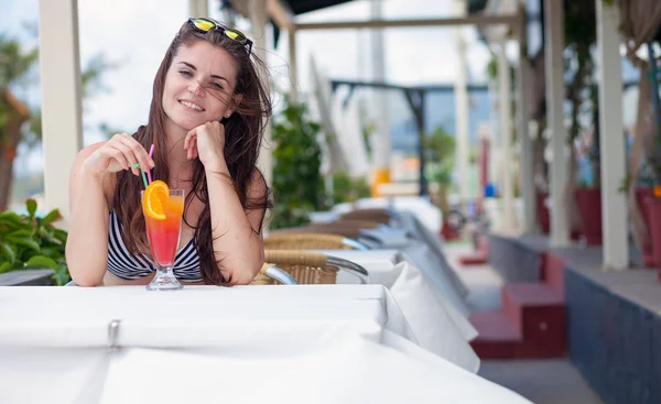 Woman with cocktail in the beach bar during tropical vacation
