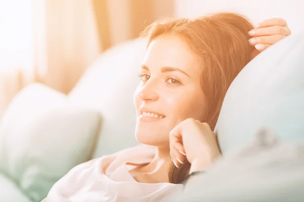 Happy young woman lying on couch and relaxing at home. Casual st