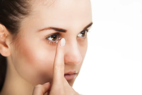 Woman putting contact lens in her eye