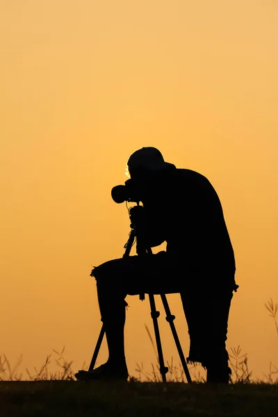 Silhouette of photographer shooting photo for a sunrise