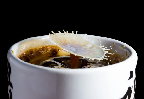 High speed photo of falling drops of milk in a cup of coffee