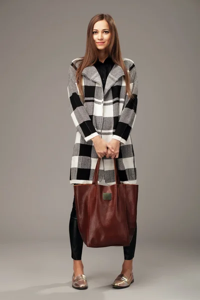 Beautiful woman with a leather brown fashion bag