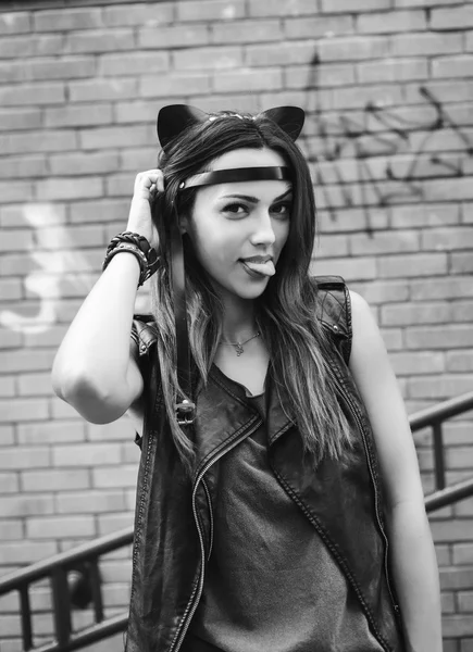Bad sexy woman with leather cat ears showing tongue