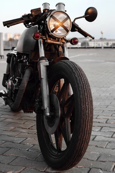 Vintage motorcycle in parking lot during sunset