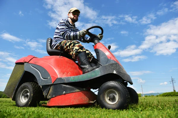 Ride-on lawn mower cutting grass.