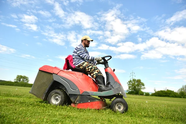 Ride-on lawn mower cutting grass.