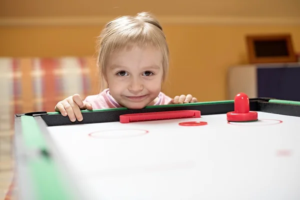 Little girl plays air hockey