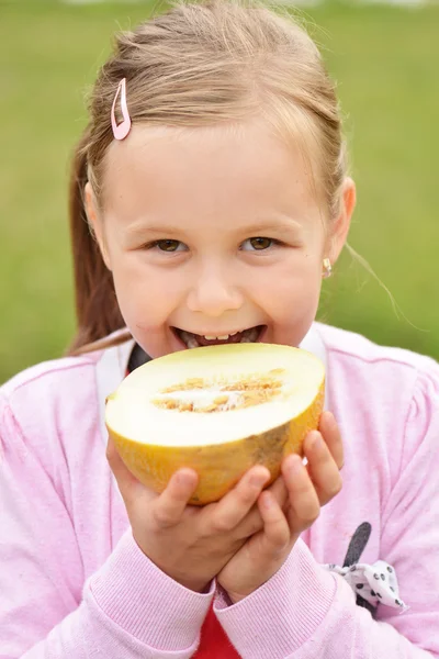 Little girl eating melon