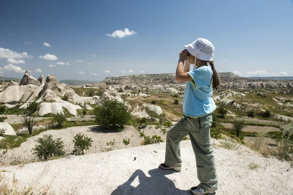 Small girl with binocular in mountains