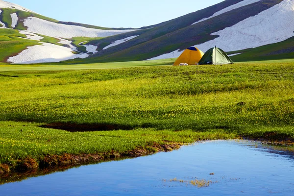 Two tents in mountains at a sunset