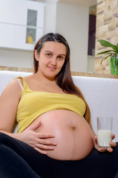Serene pregnant woman holding her swollen belly