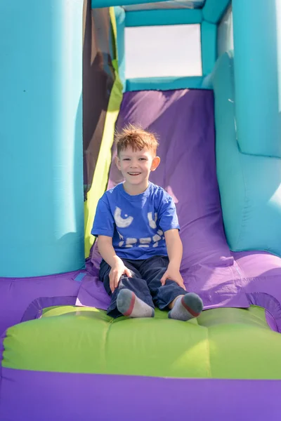 Carefree young boy playing on a bouncy castle