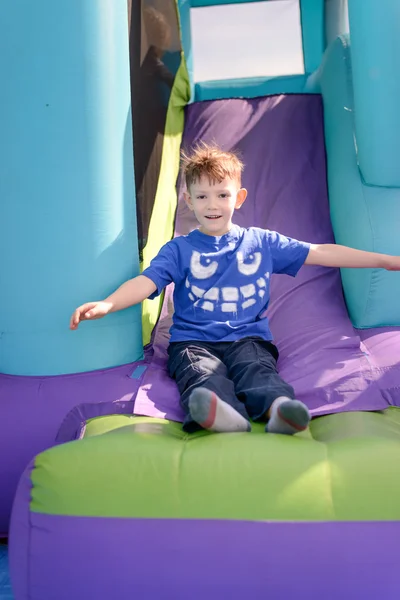 Carefree young boy playing on a bouncy castle