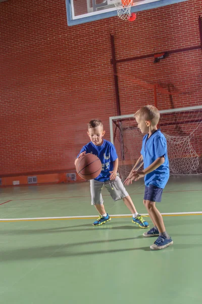Two young boys practicing their basketball