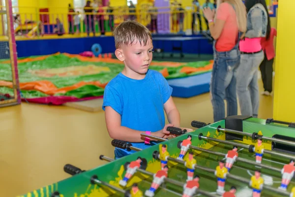 Little boy playing a table board game of soccer