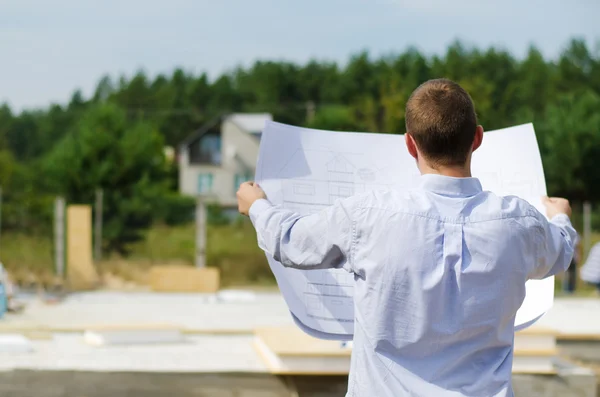 Engineer checking a building plan on site