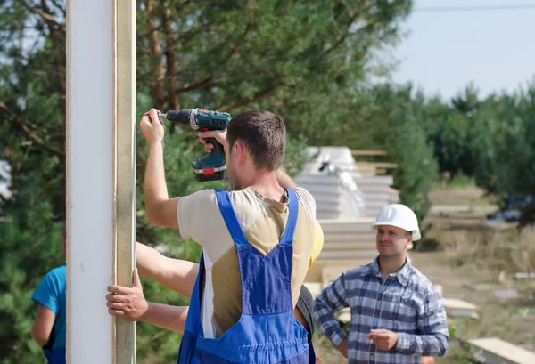 Team of builders installing insulated wall panels