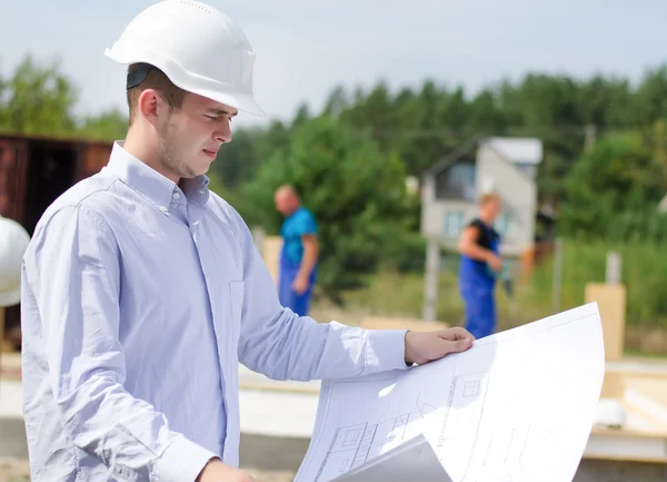 Architect or engineer checking plans on site