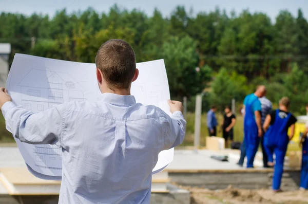 Engineer checking a building plan on site