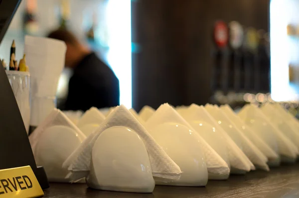 White crockery and napkins on a bar counter