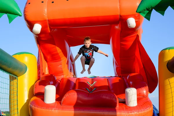 Small boy jumping in bouncy castle