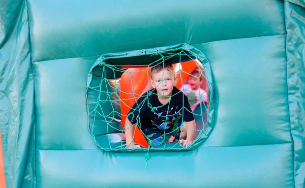 Small boy looking through window of bouncy castle