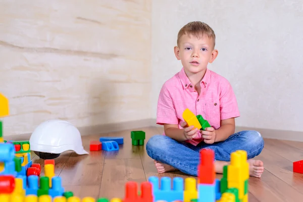 Happy young boy playing with his building blocks