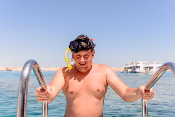 Smiling man preparing to go snorkeling