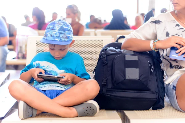 Young boy sitting in an airport terminal