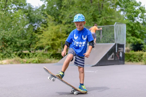 Happy boy practicing balancing on a skateboard