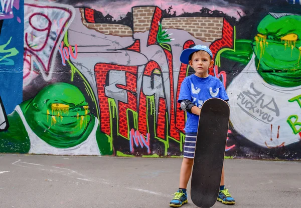 Happy young boy posing with his skateboard