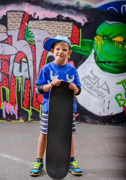 Happy young boy posing with his skateboard