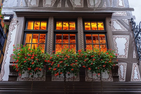 A flower bed of flowers on the window facade of the old house in europe . France
