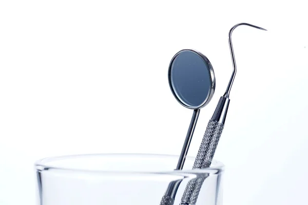 Two Dental Tools in the glass : Dental mirror and probe