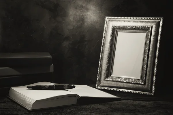 Still life of picture frame on table with diary book