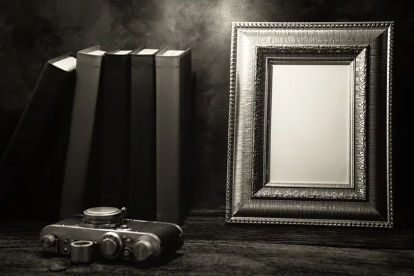 Picture frame on table with vintage camera and diary book