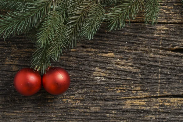 Still life of christmas ornament and tree branch on wooden board