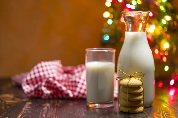 Cookie and milk on wooden table for Santa Claus.