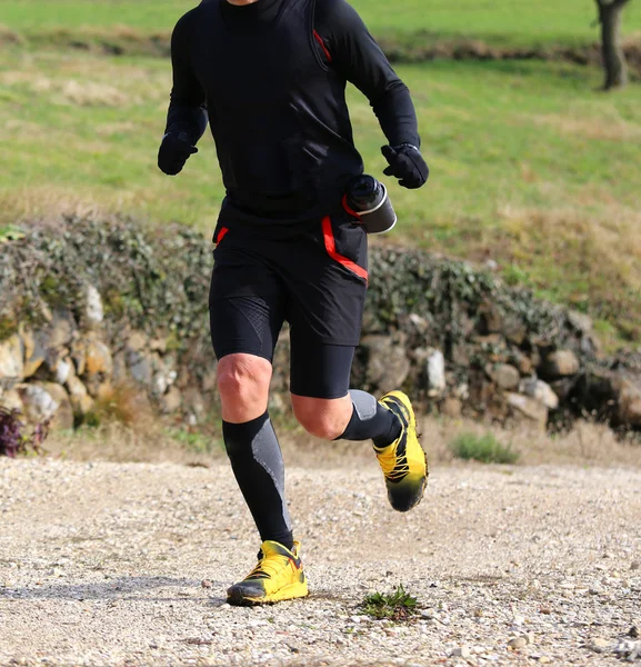 Sportsman with running shoes runs during cross country on a coun