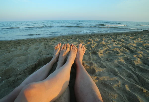 Four bare feet of the couple in love