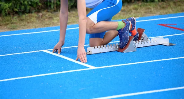 Athlete in the starting blocks of a athletic track before the st